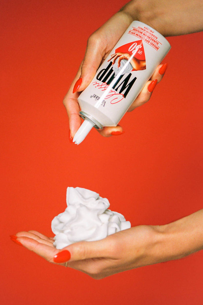 A pump bottle of Vacation Classic Whip Sunscreen with SPF 30, featuring an image of a perfect mount of sunscreen and the brand logo.