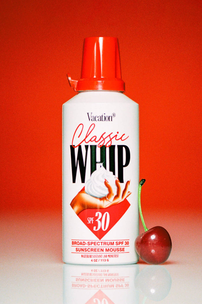 A pump bottle of Vacation Classic Whip Sunscreen with SPF 30, featuring an image of a perfect mount of sunscreen and the brand logo.
