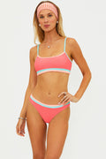 Woman wearing a pink bikini with a white background