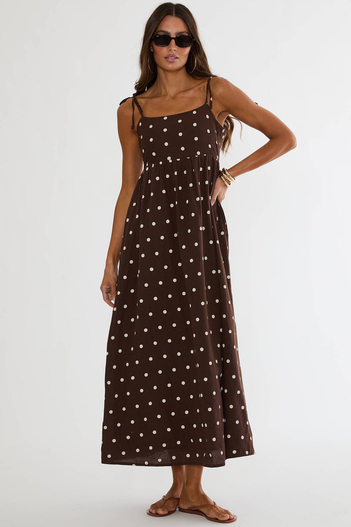 Woman wearing a brown polka dot dress on a white background