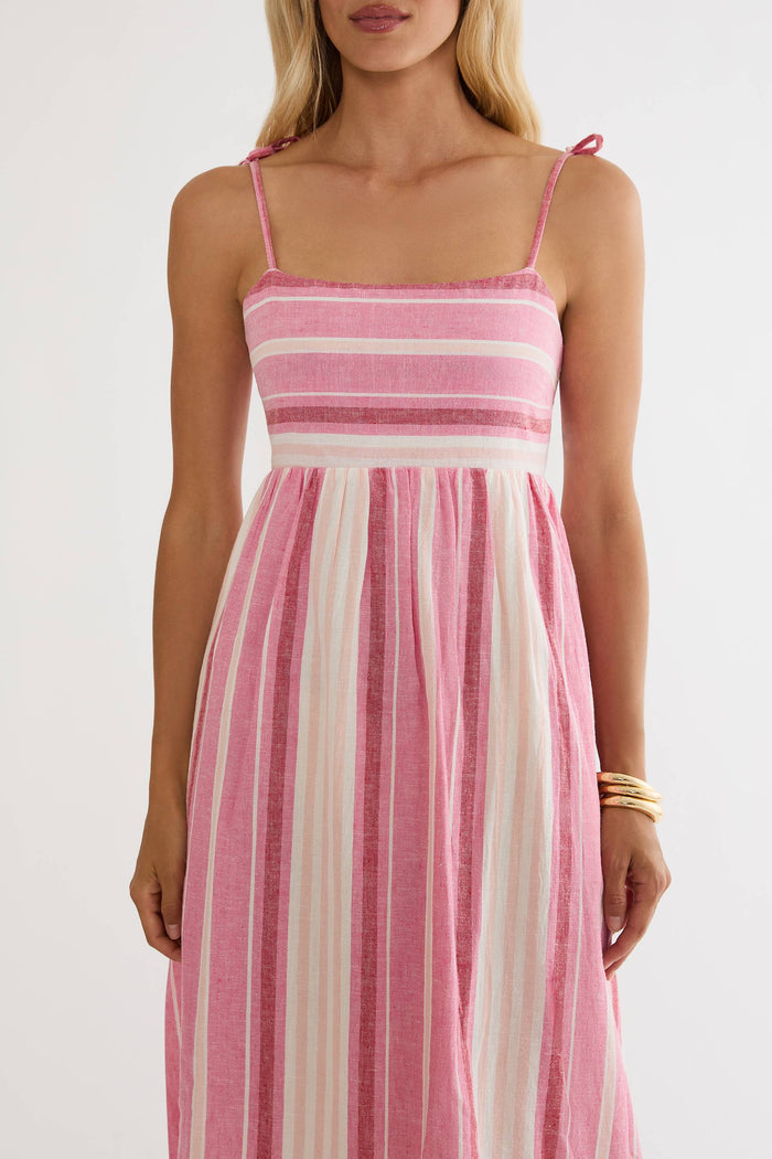 Woman wearing a pink and white striped dress on a plain background