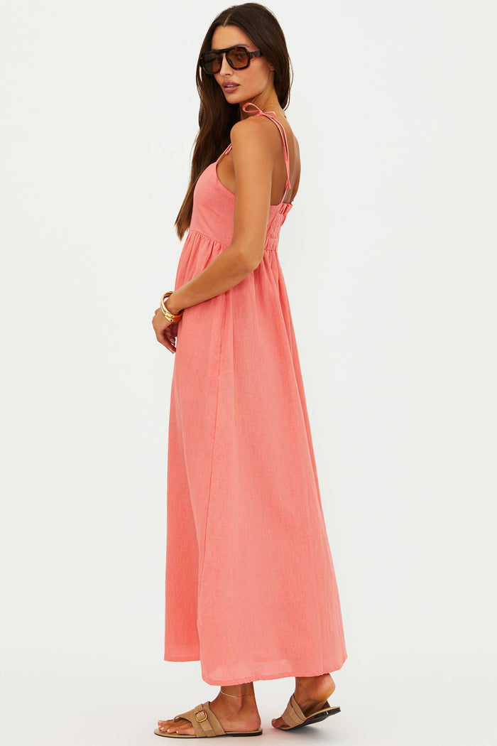Woman wearing a coral pink dress on a white background