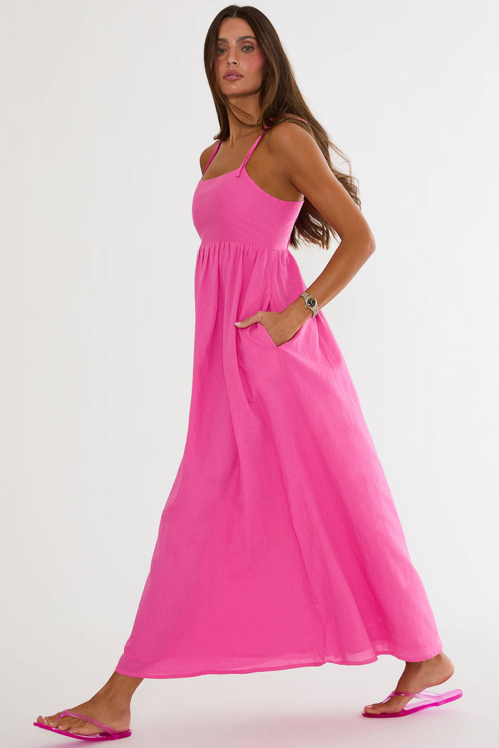 Woman wearing a pink maxi dress on a white background
