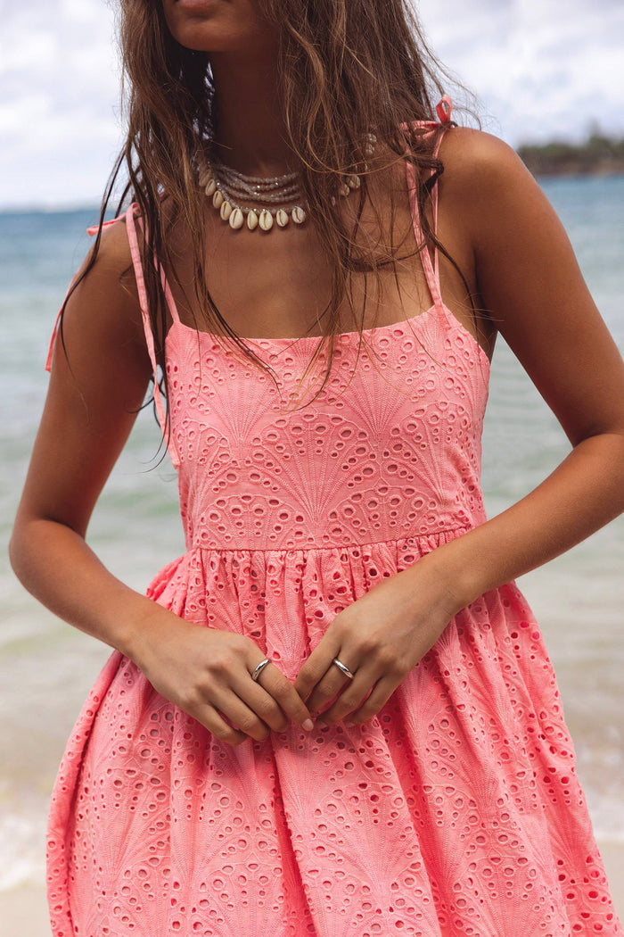 Woman wearing a pink dress on a beach