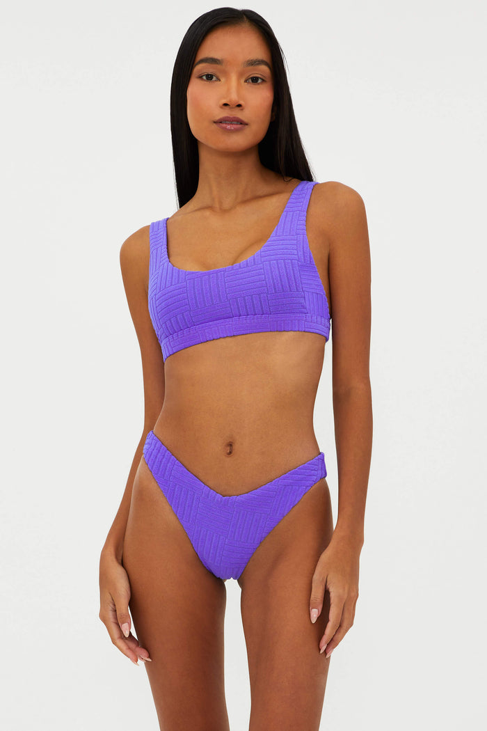 Woman wearing a purple bikini set on a white background