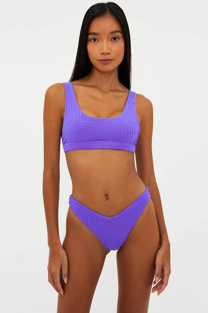 Woman wearing a purple bikini set on a white background