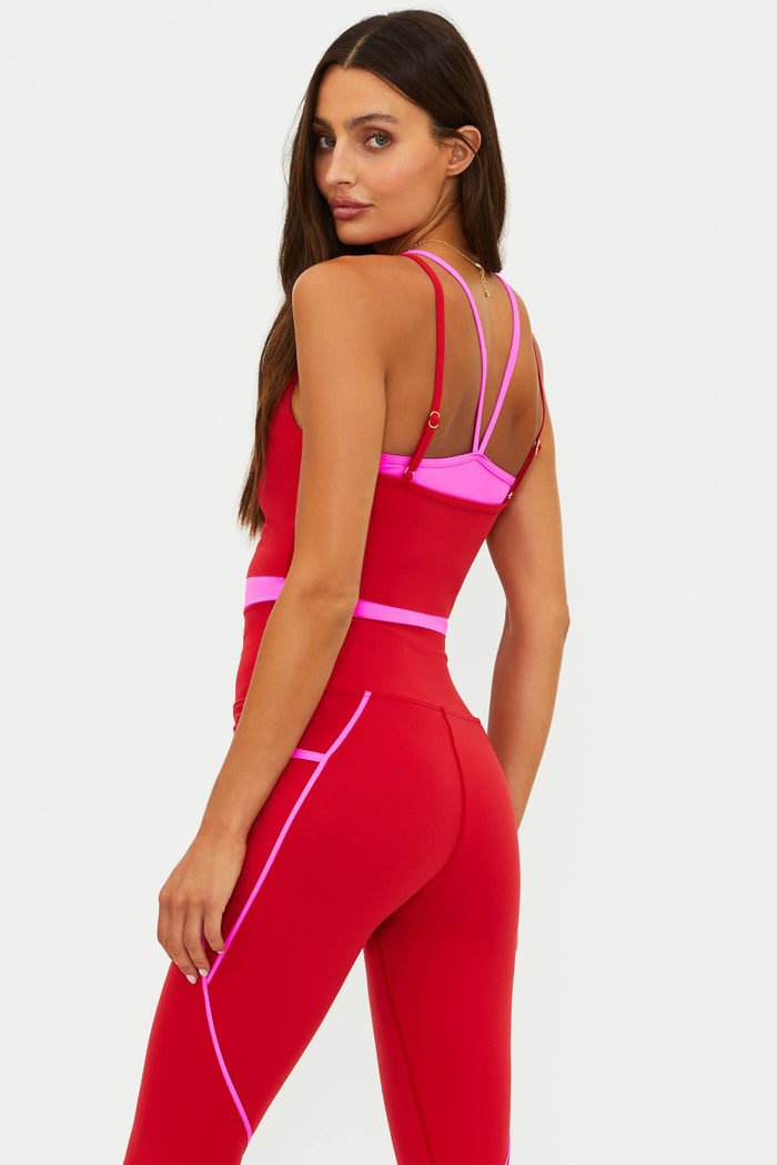 Woman wearing a red and pink jumpsuit on a white background