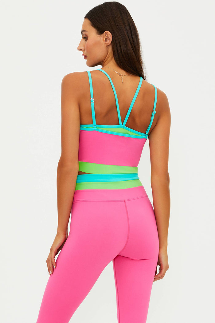 Woman wearing a pink and green sports outfit on a white background