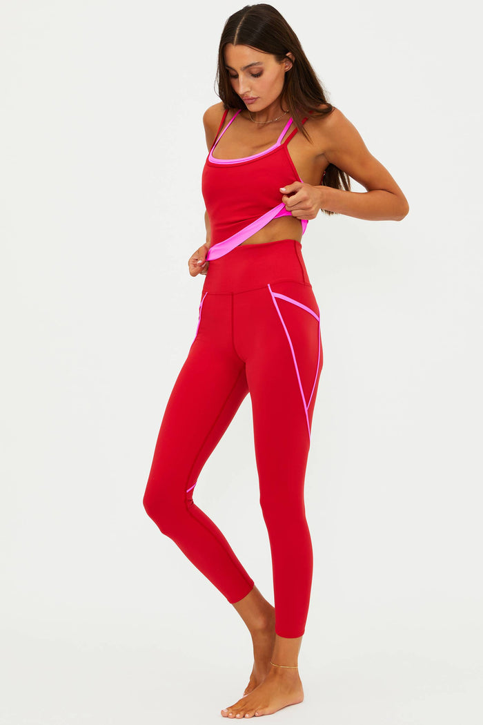 Woman wearing a red and pink athletic outfit on a white background