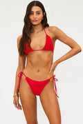 Woman wearing a red bikini against a white background