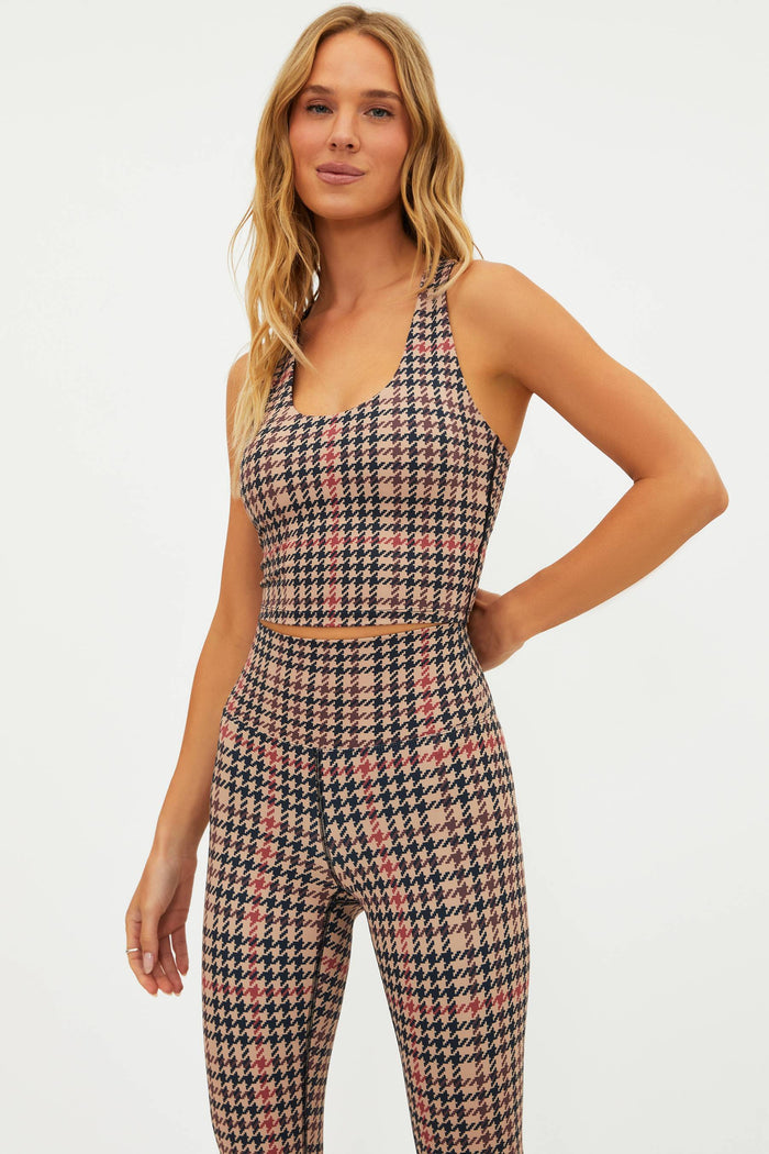 Woman wearing a houndstooth patterned outfit on a white background