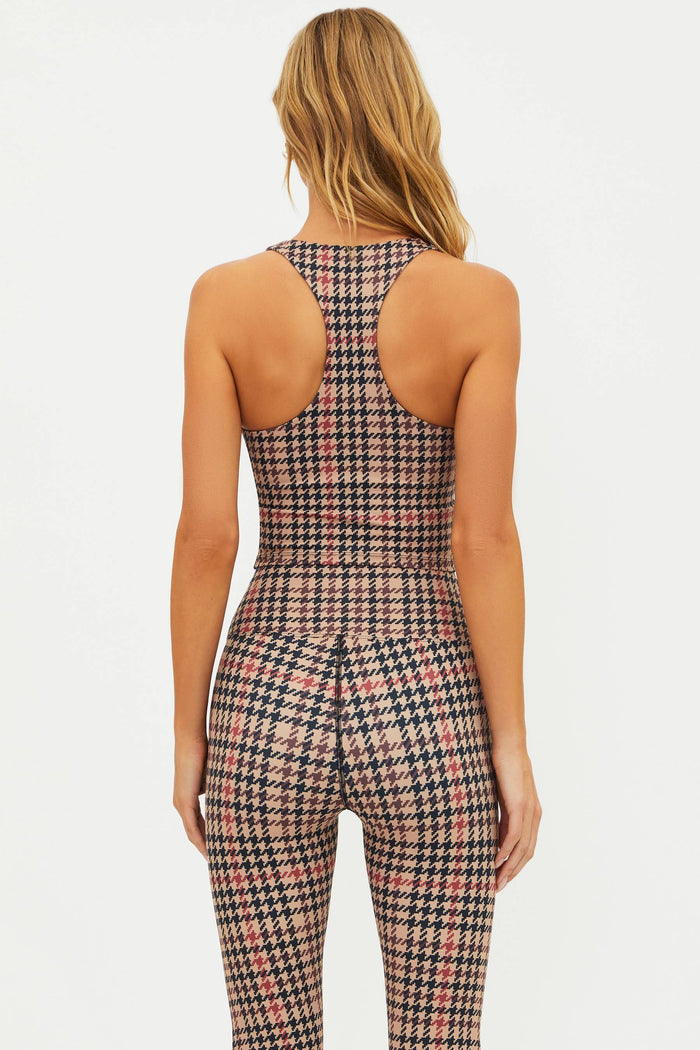 Person wearing a houndstooth patterned jumpsuit on a white background