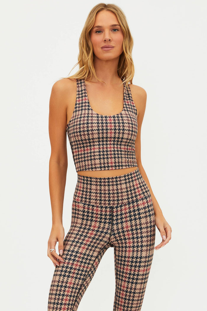 Woman wearing a plaid sports bra and leggings set on a white background