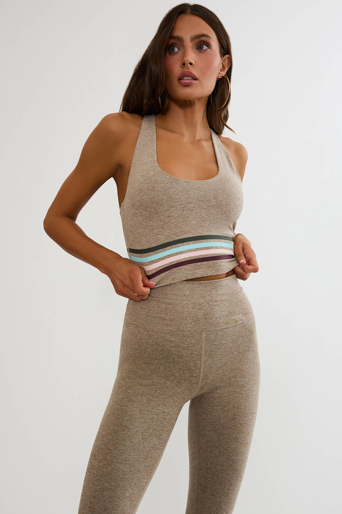 Beige workout top with colorful lining around the ribcage.