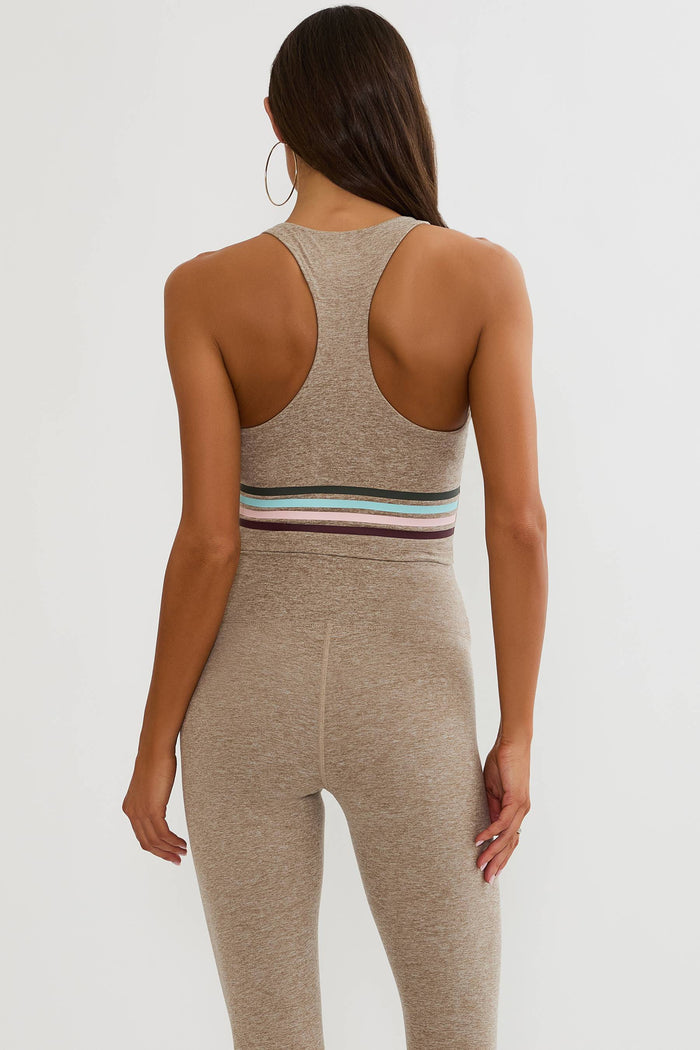 Beige workout top with colorful lining around the ribcage.