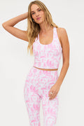 Woman wearing a pink and white patterned outfit on a light gray background