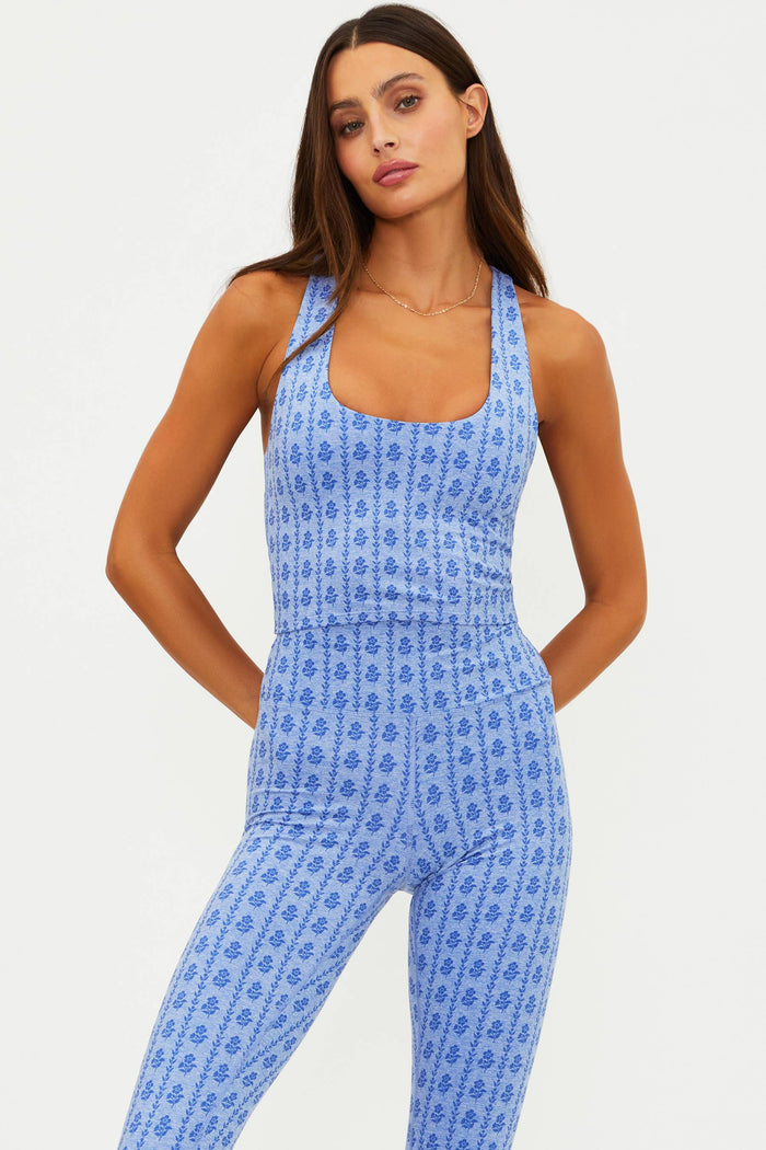 Woman wearing a blue floral jumpsuit on a white background