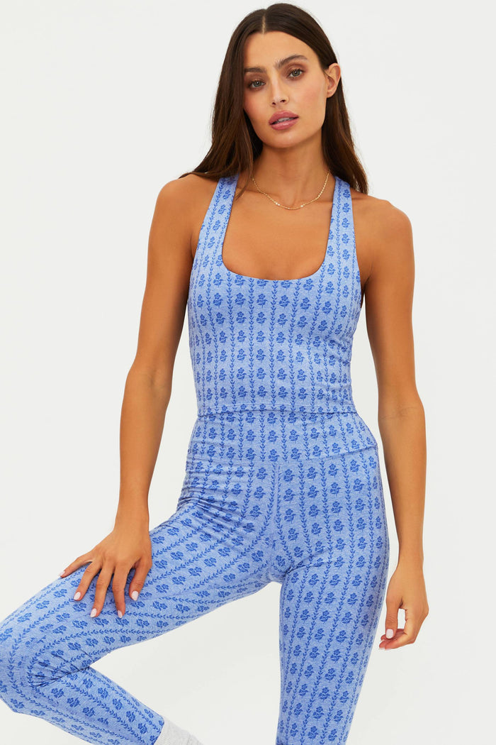 Woman wearing a blue patterned jumpsuit on a white background
