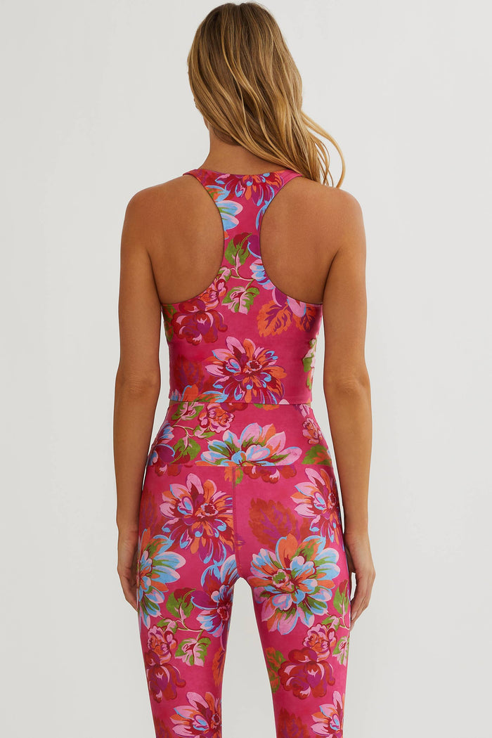 Woman wearing a pink floral jumpsuit on a white background