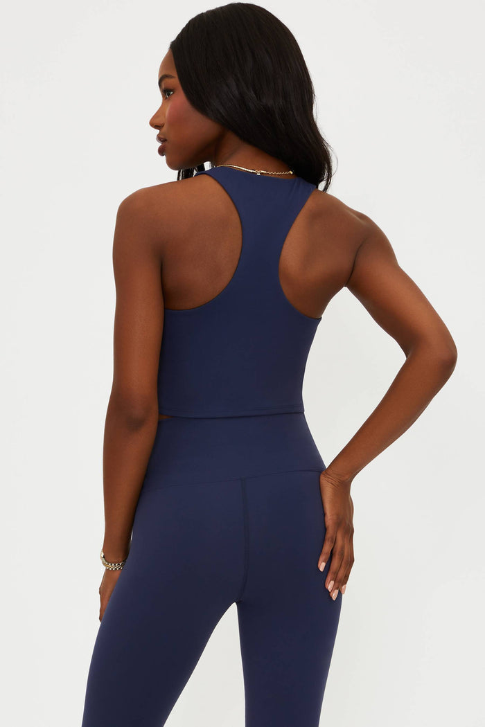 Woman wearing a navy blue jumpsuit on a white background