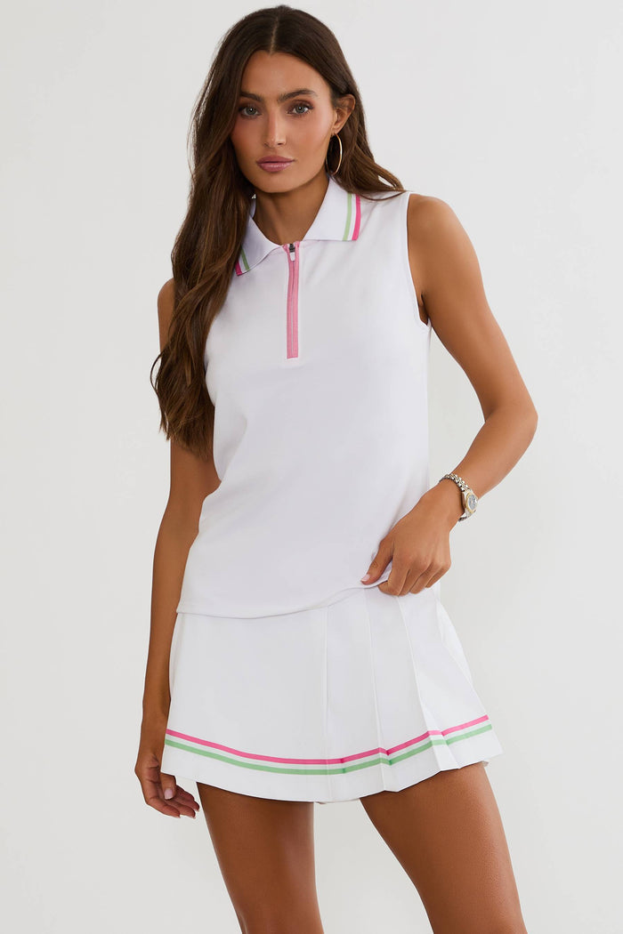 Woman wearing a white dress with pink and green trim on a white background
